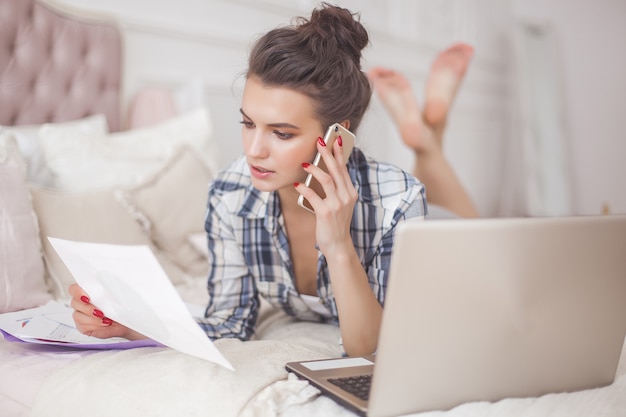 Jovem mulher atraente, trabalhando em casa no laptop