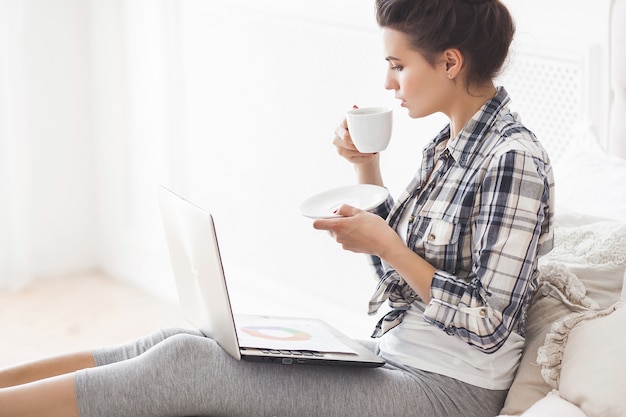 Jovem mulher atraente trabalhando em um laptop