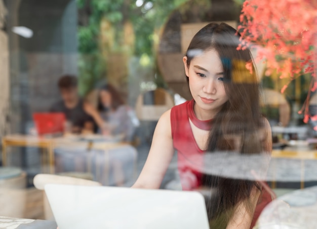 Foto jovem mulher atraente usando laptop na cafeteria - conexão social e conceito de estilo de vida