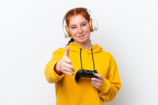 Jovem mulher avermelhada brincando com um controlador de videogame isolado em fundo branco apertando as mãos para fechar um bom negócio