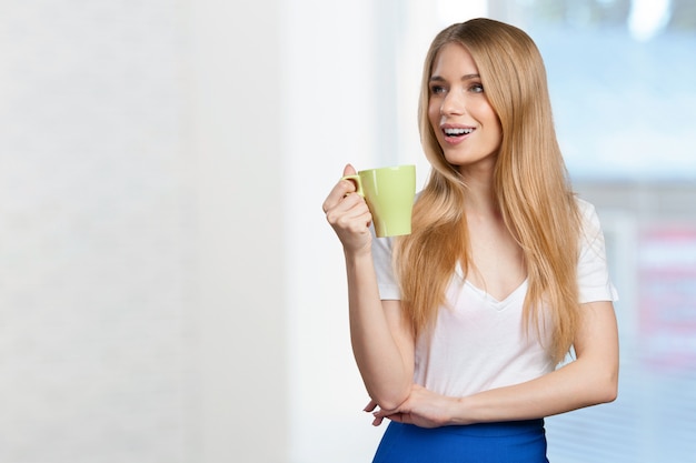 Jovem mulher bebe café ou chá