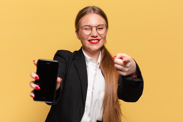 Jovem mulher bonita apontando o conceito de telefone inteligente de gesto