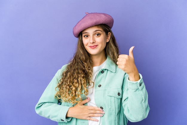 Jovem mulher bonita caucasiana toca a barriga, sorri suavemente, conceito de comer e satisfação.