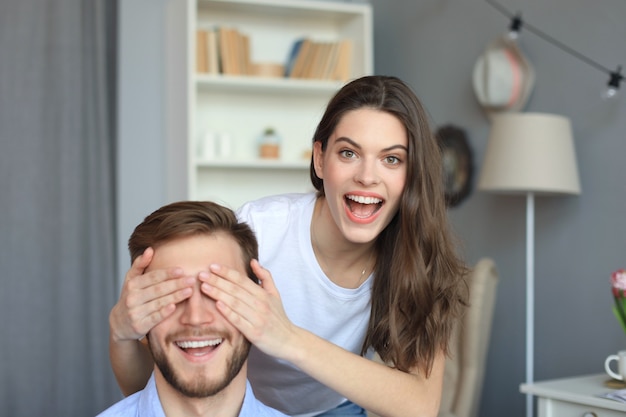 Jovem mulher bonita cobrindo os olhos do marido.