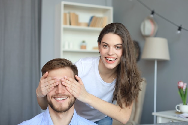 Jovem mulher bonita cobrindo os olhos do marido.