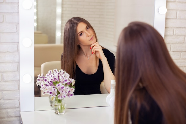 Jovem mulher bonita com cabelo longo e saudável em um salão de cabeleireiro.