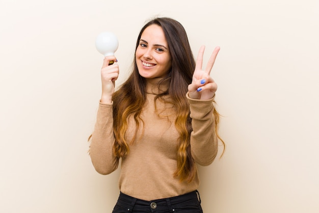 Jovem mulher bonita com lâmpada, tendo uma ideia