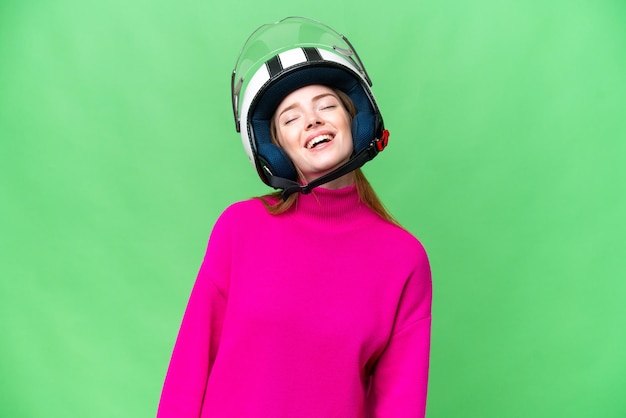 Jovem mulher bonita com um capacete de motocicleta sobre fundo croma isolado rindo