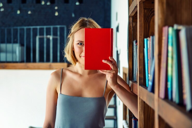 Foto jovem mulher bonita com um livro vermelho nas mãos dela