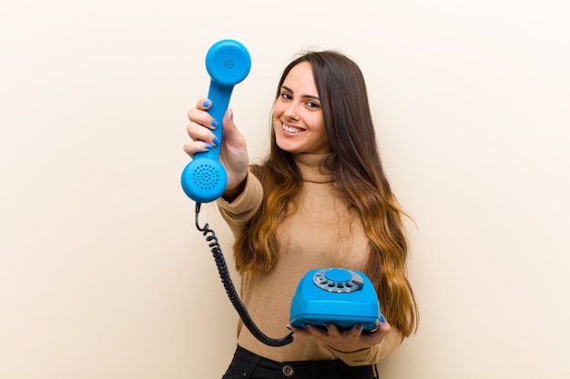 Jovem mulher bonita com um telefone azul vintage