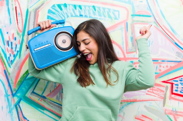 Jovem mulher bonita com uma parede de graffiti de rádio vintage