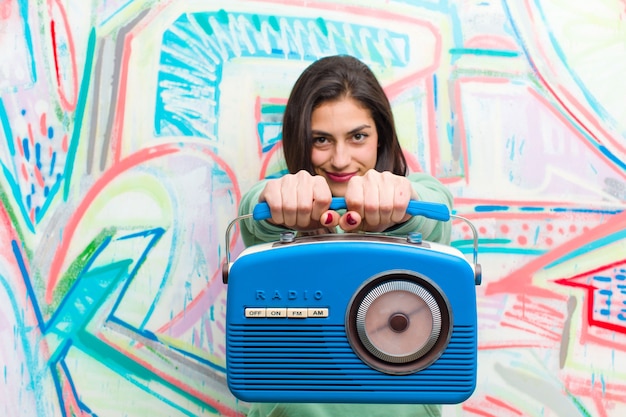 Foto jovem mulher bonita com uma parede de graffiti de rádio vintage