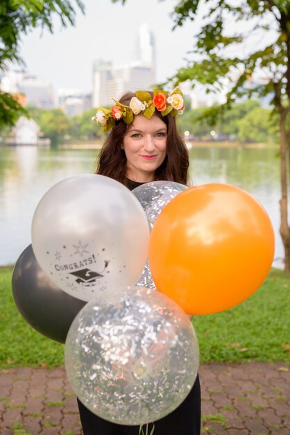 Jovem mulher bonita comemorando a formatura no parque