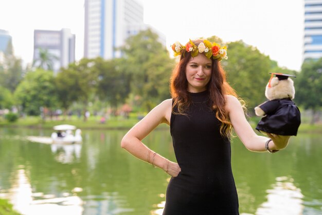 Jovem mulher bonita comemorando a formatura no parque