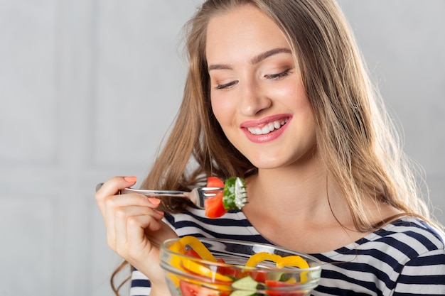 Foto jovem mulher bonita comendo alimentos saudáveis - salada