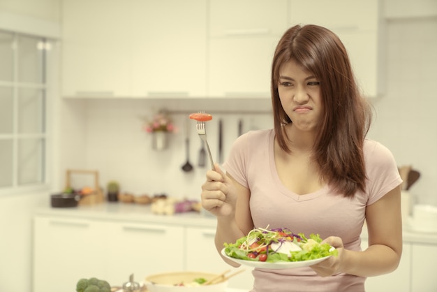 Jovem mulher bonita comendo salada