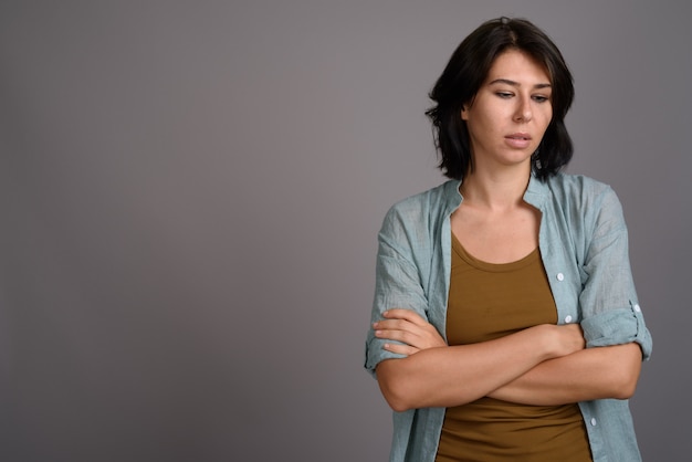 Jovem mulher bonita contra um fundo cinza