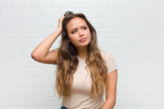 jovem mulher bonita contra uma parede branca