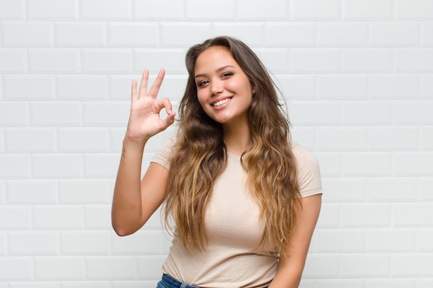 jovem mulher bonita contra uma parede branca