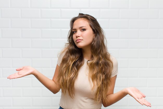 jovem mulher bonita contra uma parede branca