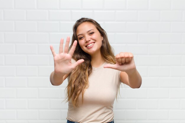 jovem mulher bonita contra uma parede branca