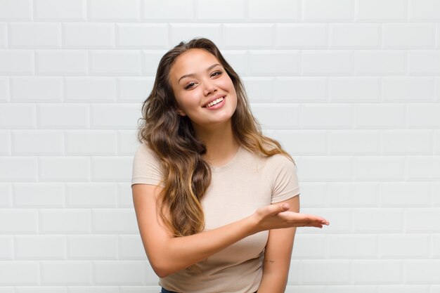 Jovem mulher bonita contra uma parede branca