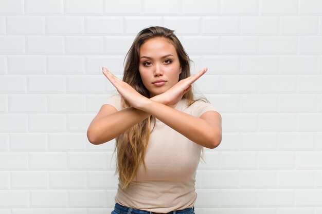 Jovem mulher bonita contra uma parede branca