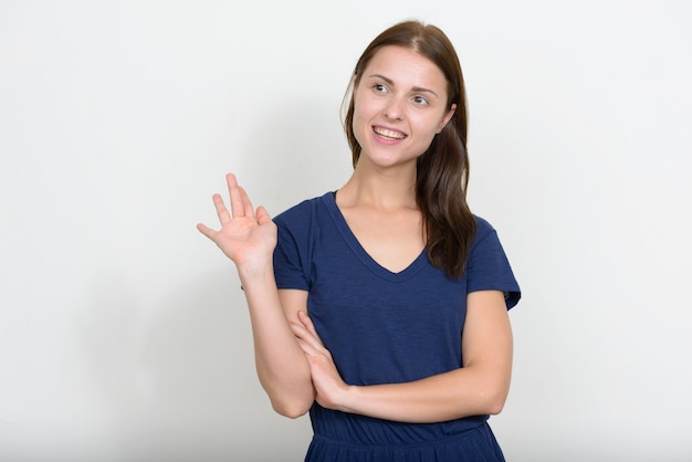 Jovem mulher bonita contra uma parede branca