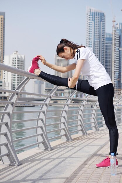 Jovem mulher bonita correndo e correndo na manhã no parque da cidade. Mulher no conceito de saúde e fitness do esporte ao ar livre