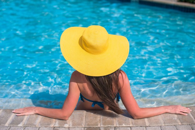 Jovem mulher bonita curtindo férias na piscina