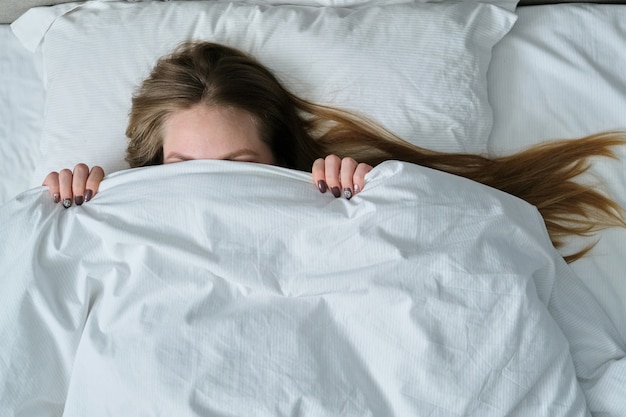 Jovem mulher bonita deitada na almofada na cama