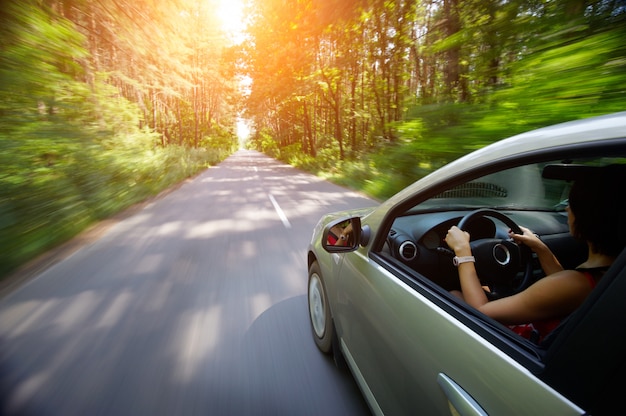 Jovem mulher bonita dirigindo carro - vista traseira