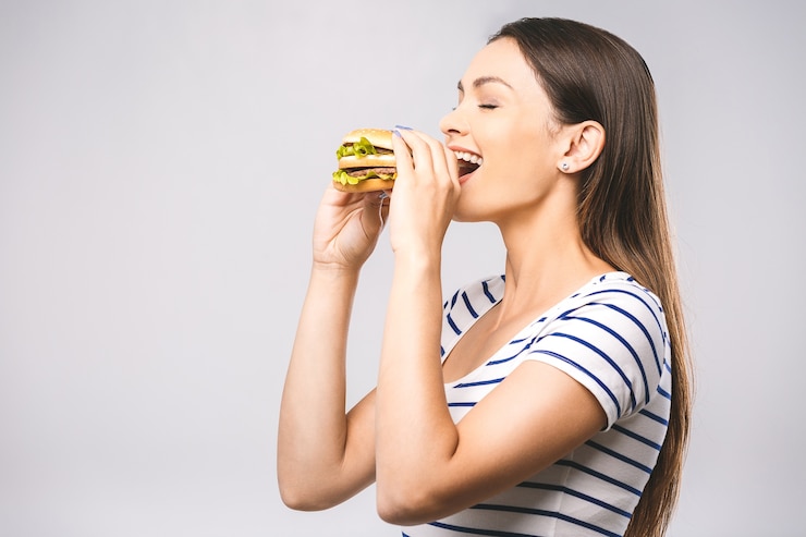 Foto jovem mulher bonita e feliz comendo hambúrguer