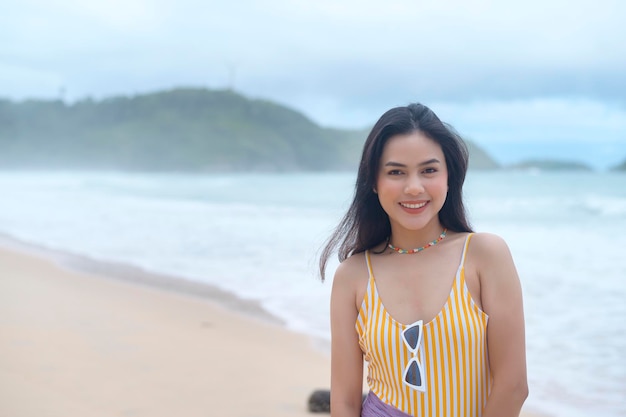 Jovem mulher bonita em biquíni curtindo e relaxando na praia