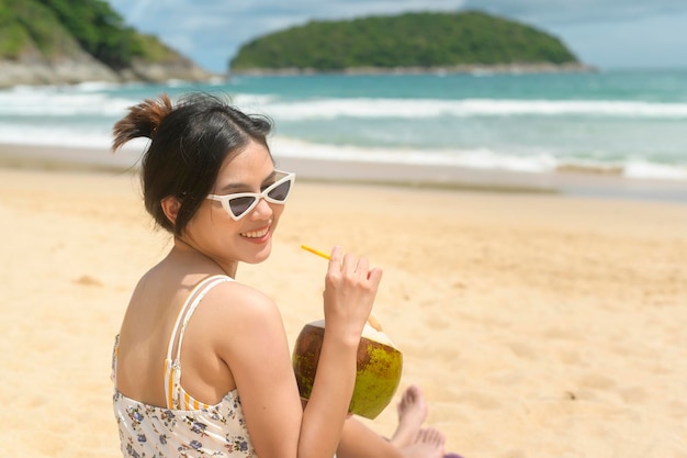 Jovem mulher bonita em biquíni curtindo e relaxando na praia