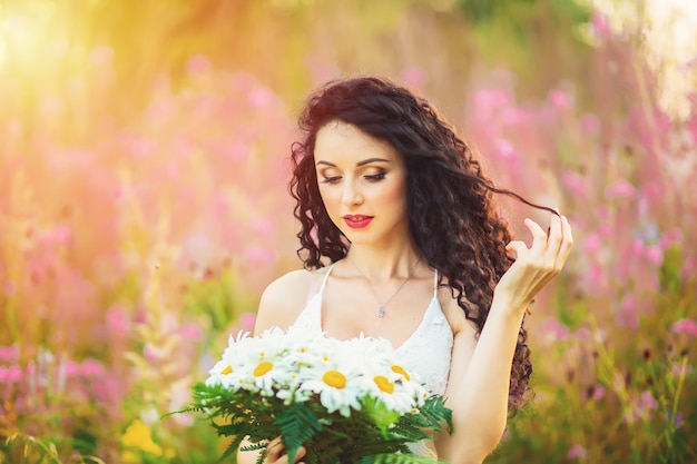 Jovem mulher bonita em um campo de flores