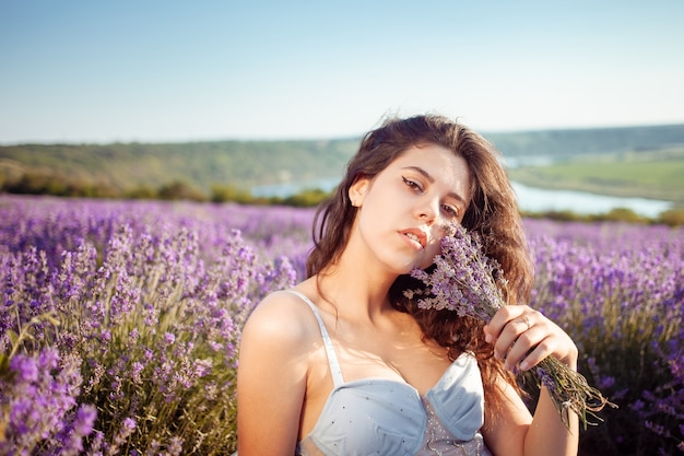 Jovem mulher bonita em um campo de lavanda