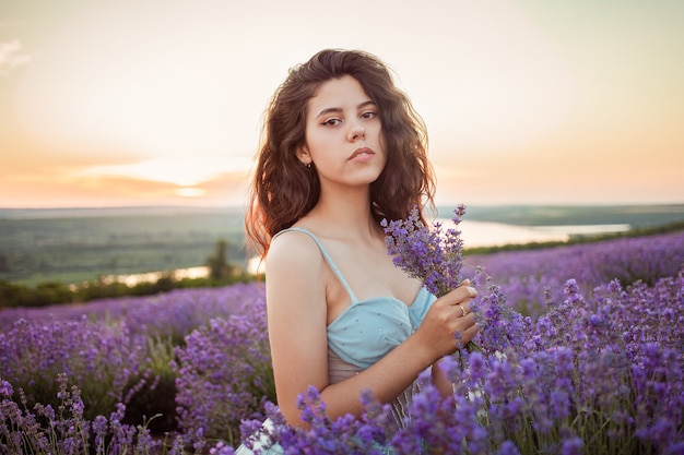 Jovem mulher bonita em um campo de lavanda