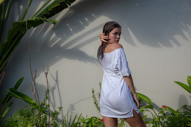Jovem mulher bonita em uma camiseta branca tropics