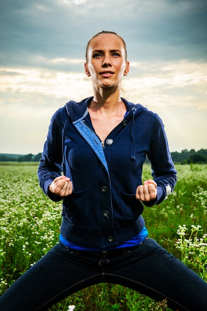 Foto jovem mulher bonita fazendo yoga em um prado