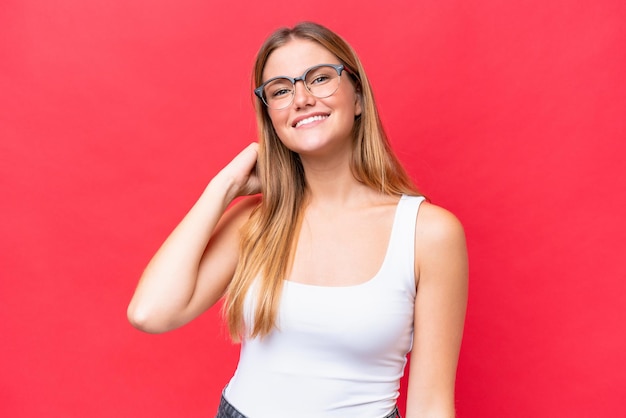 Jovem mulher bonita isolada em fundo vermelho rindo