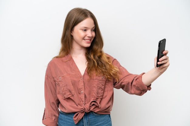 Jovem mulher bonita isolada no fundo branco fazendo uma selfie