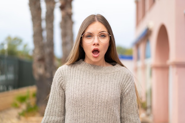 Jovem mulher bonita loira com óculos e expressão de surpresa