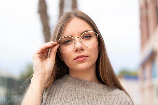 Jovem mulher bonita loira com óculos e expressão frustrada