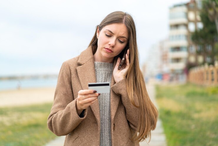 Foto jovem mulher bonita loira comprando com o celular com cartão de crédito