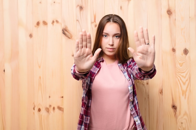 Jovem mulher bonita loira contra a parede de madeira