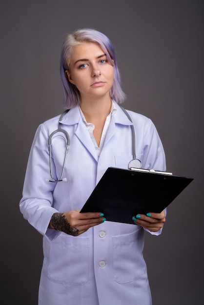 jovem mulher bonita médica com cabelo curto colorido