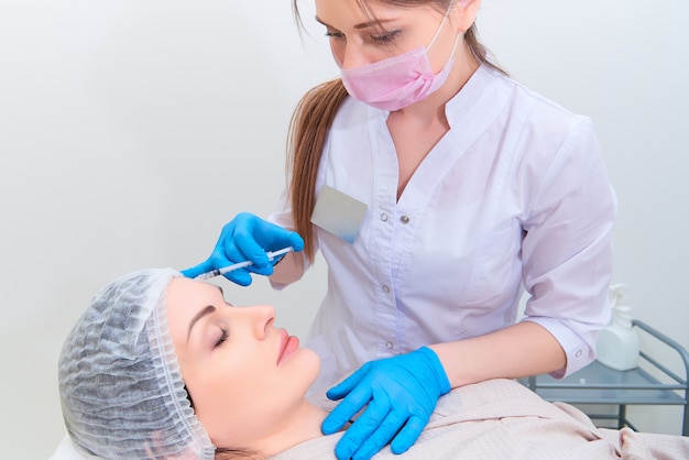 Jovem mulher bonita na clínica estética da cosmetologia.