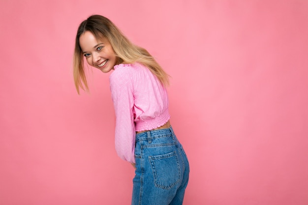 Jovem mulher bonita na moda na moda rosa corte top feminino positivo mostra facial