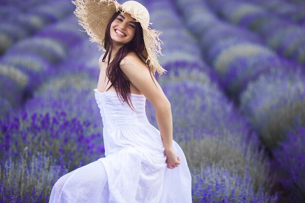 Jovem mulher bonita no campo de lavanda. Senhora em fundo de verão